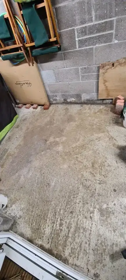The cleaned floor of a garage where a chemical spill was previously visible.