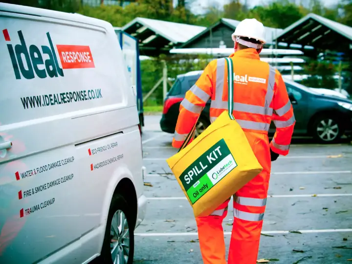 A cleaning technician walking to an Ideal Response branded van.