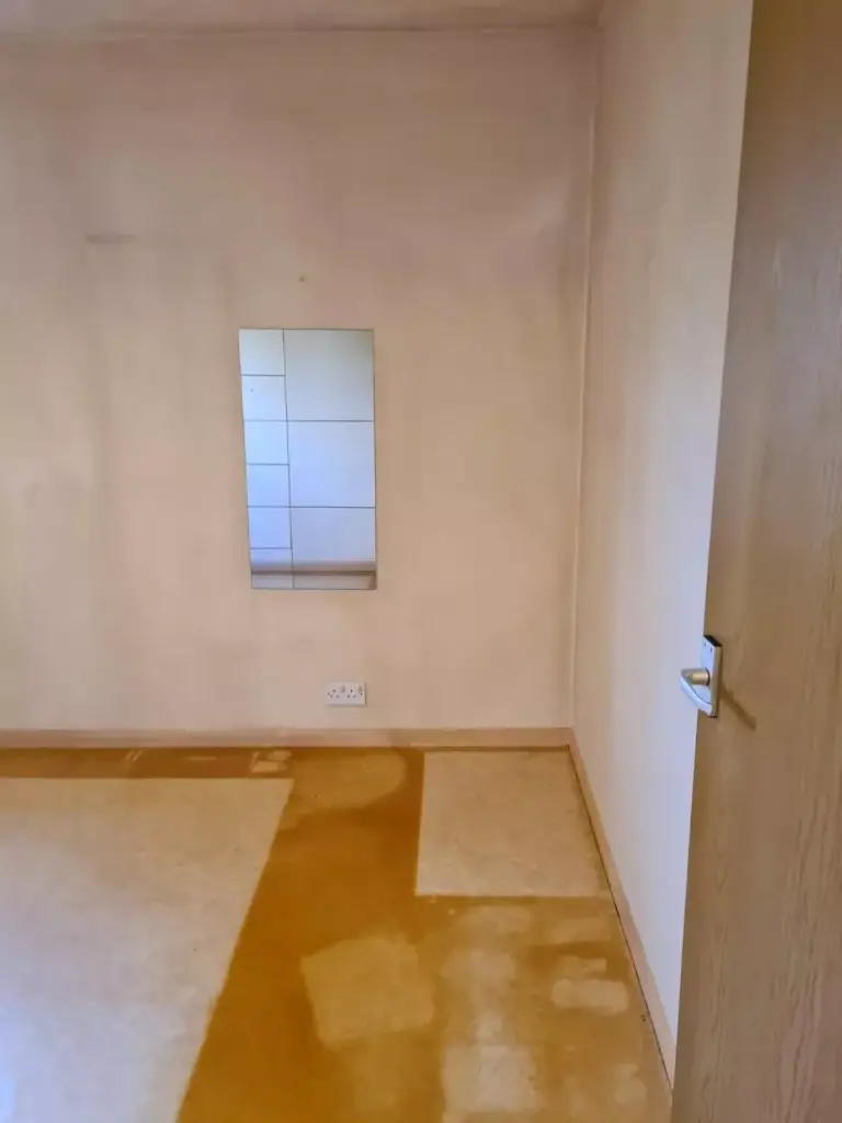 A room stained with tar from cigarette smoke and patches that have been cleaned.