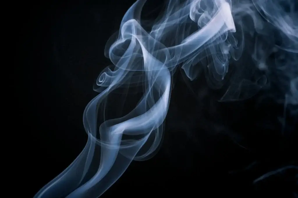 A column of swirling smoke against a black background.