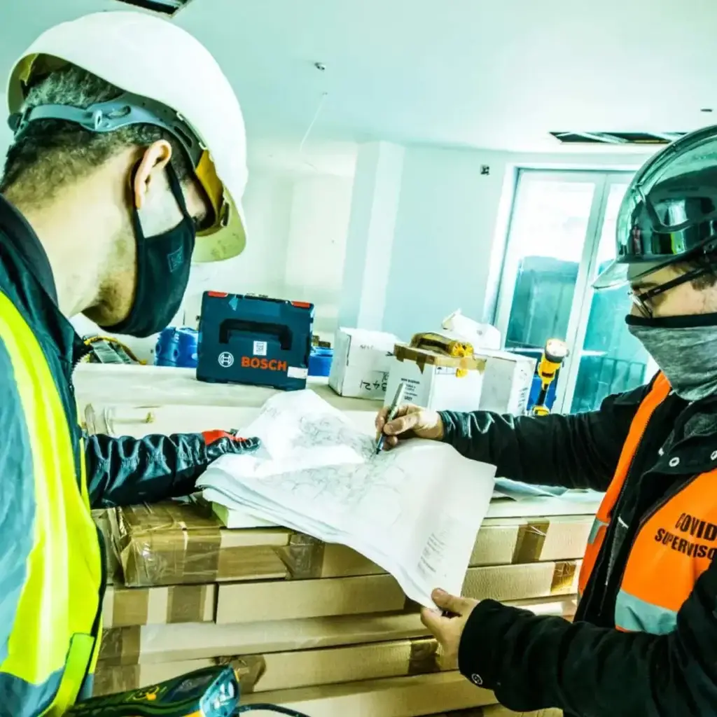 Two people reviewing plans in a building