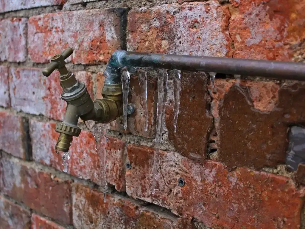 A frozen water pipe with icicles